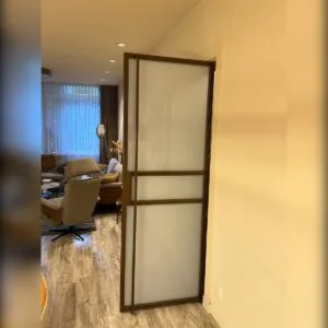 gouden scharnierdeur met melkglas tussen woonkamer en hal