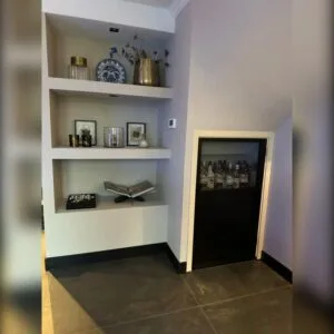 mini stalen deur met glas in een nis naast inbouwkasten